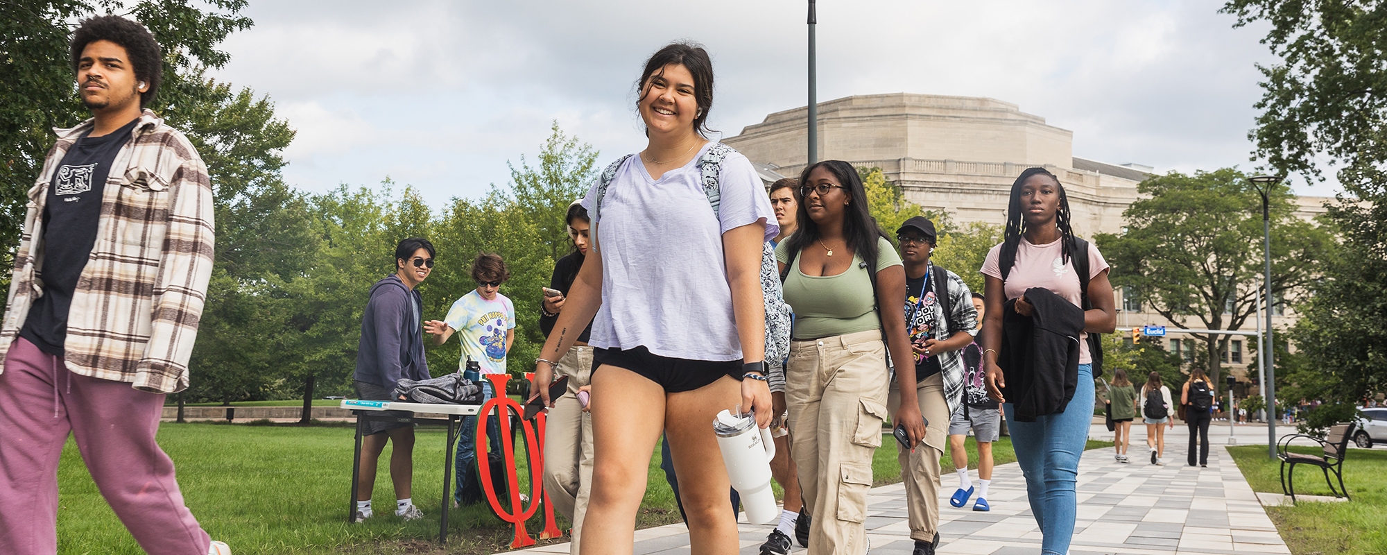 Students wearing backpacks walk on the Binary Walkway from Euclid Avenue to the Case Quad